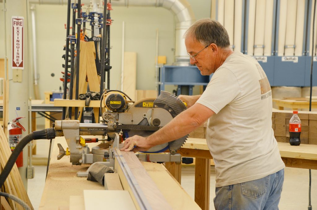 Jim Adams, a manager at The DIY Woodshop, cuts one of 2,000-plus handles for a client.