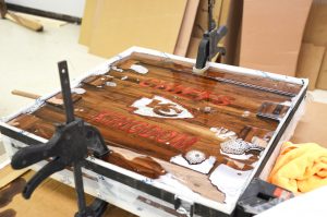 The first step of the epoxy process. A member of The DIY Woodshop showed Kansas City spirit through creating the one-of-kind Chiefs plaque. 