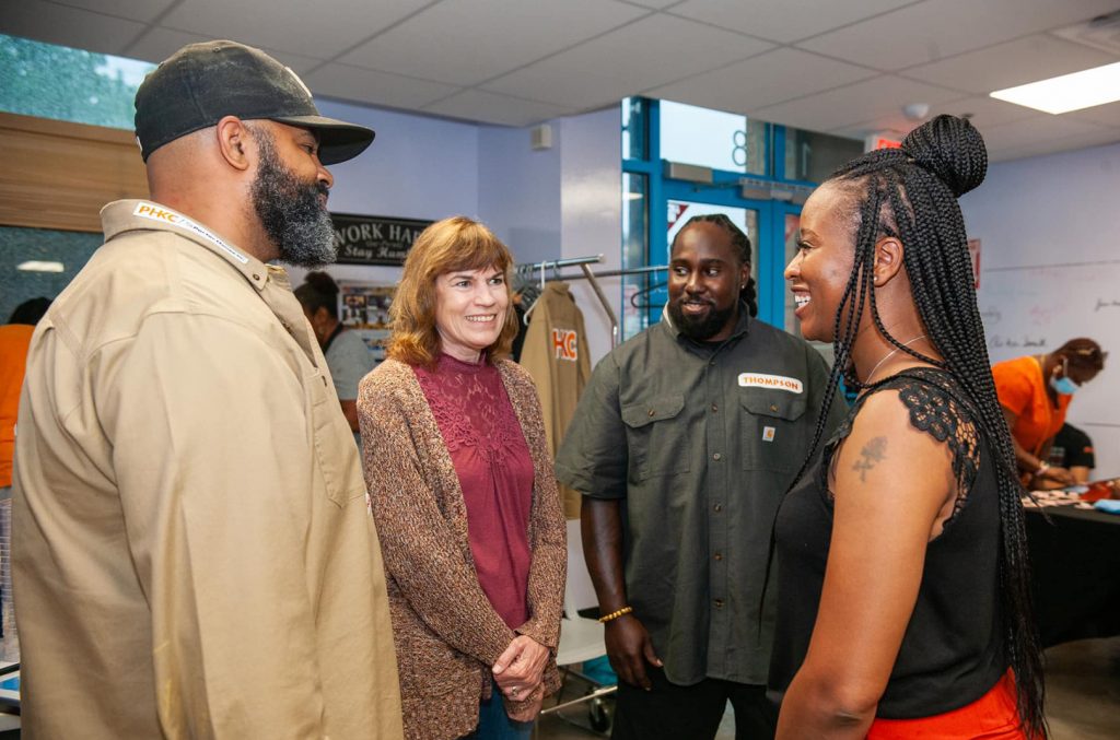 Dan Smith, Maria Meyers and Charon Thompson, from left, talk with an attendee at the Porter House KC's 2021 open house at 18th and Vine