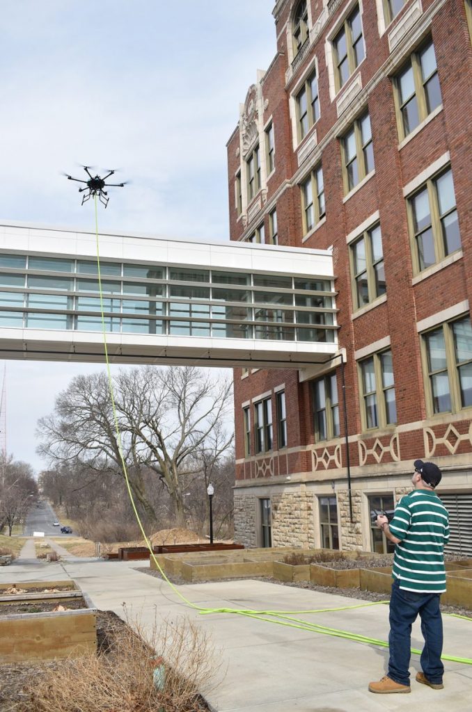 Drone pilot Justin Lee maneuvers a Drone Wash cleaning drone at Plexpod Westport Commons