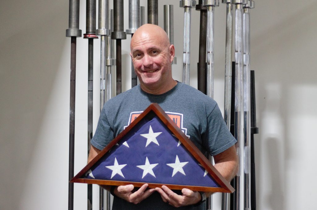Jay Fleer, Mission Barbell Club, holding his grandfather's flag, awarded for U.S. military service in World War II