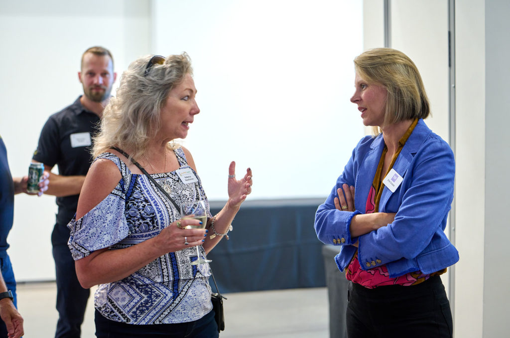 Rebecca MacKinnon, SoulFIRE Health, speaks with Erin Croom, of Atlanta-based Small Bites Adventure Club, at the NXTSTAGE Community Health and Vibrancy Pilot Competition